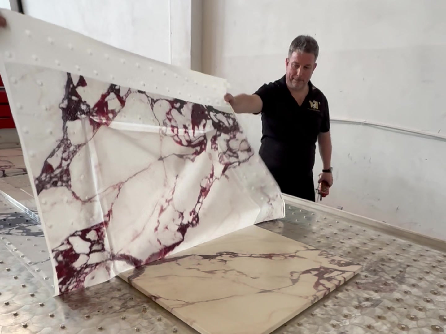 Roberto Cavaliere lifting the temporary carrier to reveal the printed countertop.